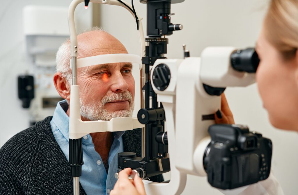 A female optometrist carefully examining a man's eyes to diagnose the cause of eye floaters.