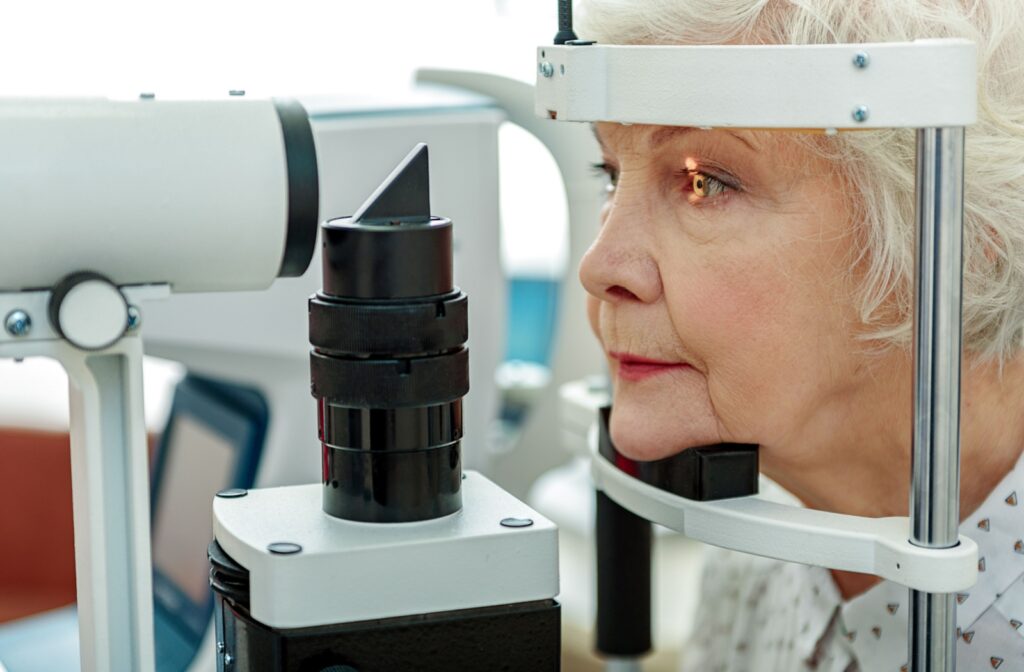 An older adult undergoing an eye examination with a slit lamp at an ophthalmologist's office.