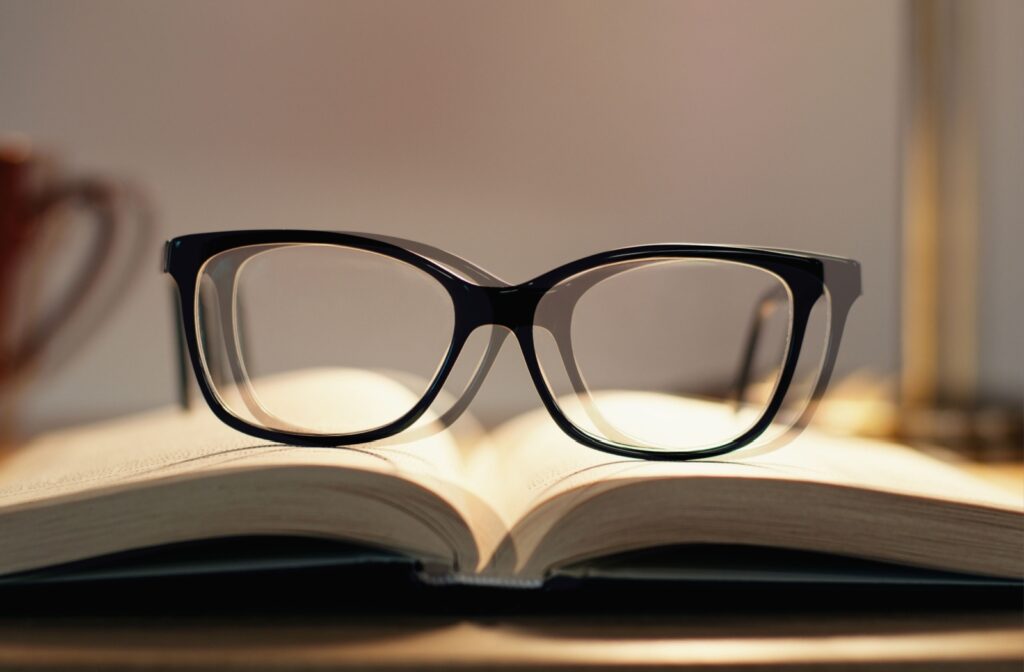 Double vision of black framed eyeglasses sitting on the pages of an open book.