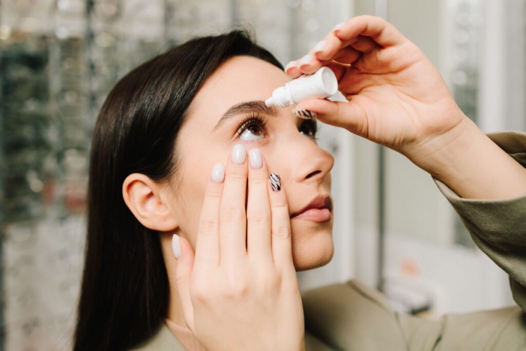An eye care patient using eye drops for dry eye relief.