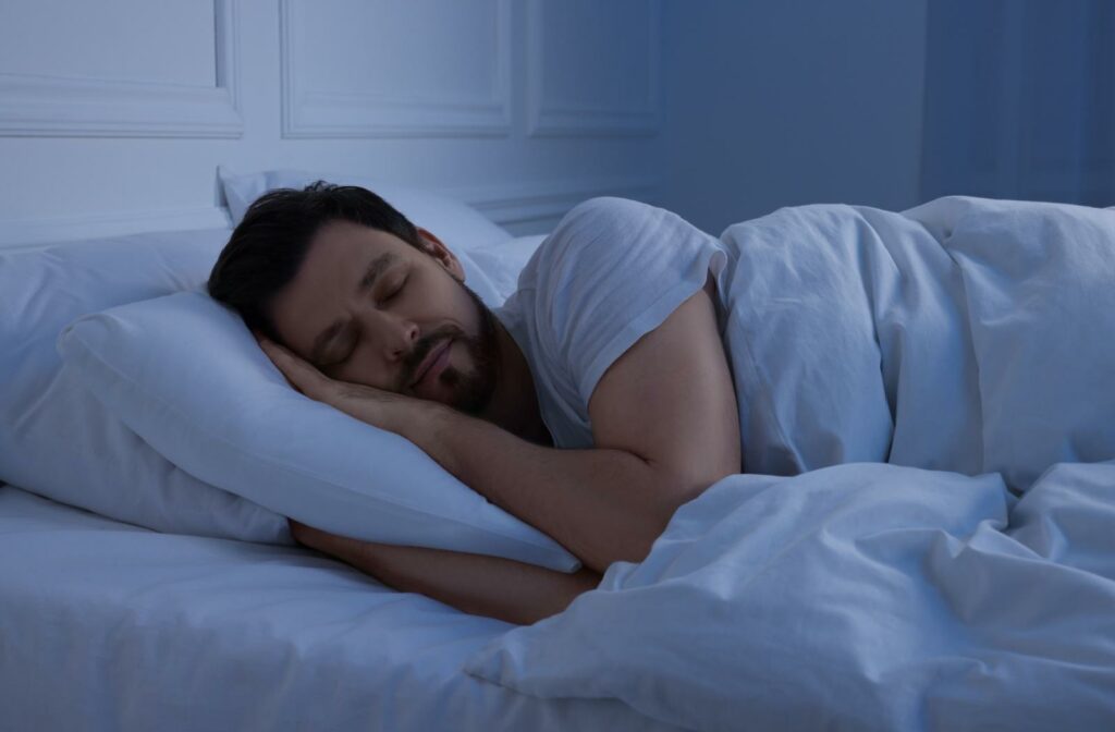 A person in bed, sleeping without contact lenses in to protect their vision.